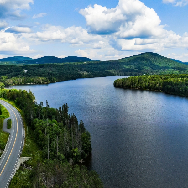 Overhead view of road alongside Lake Champlain in Vermont with mountains in the background