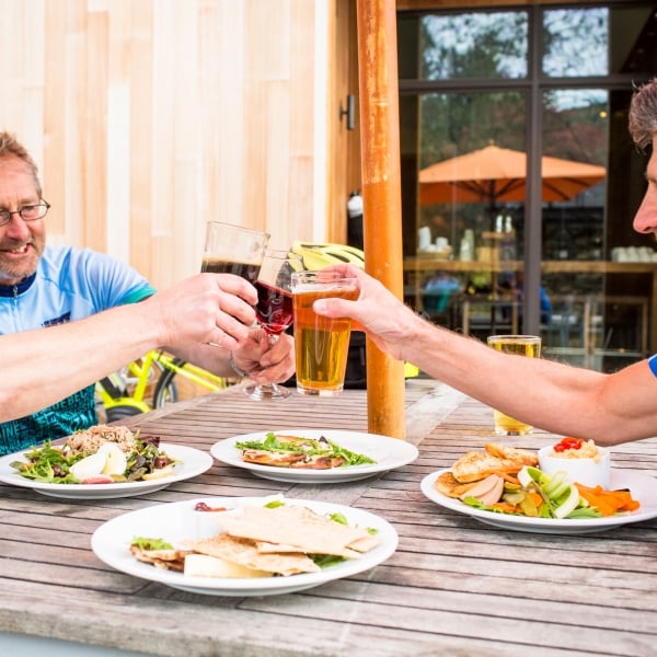 Three people sharing a meal, beer, and wine during a lunch in Stowe, Vermont, while on a bike tour